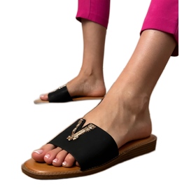 Les tongs noirs avec une décoration dorée