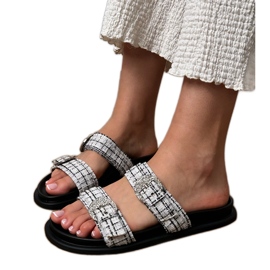 Les tongs blancs avec des rayures et des zircons sur les pinces