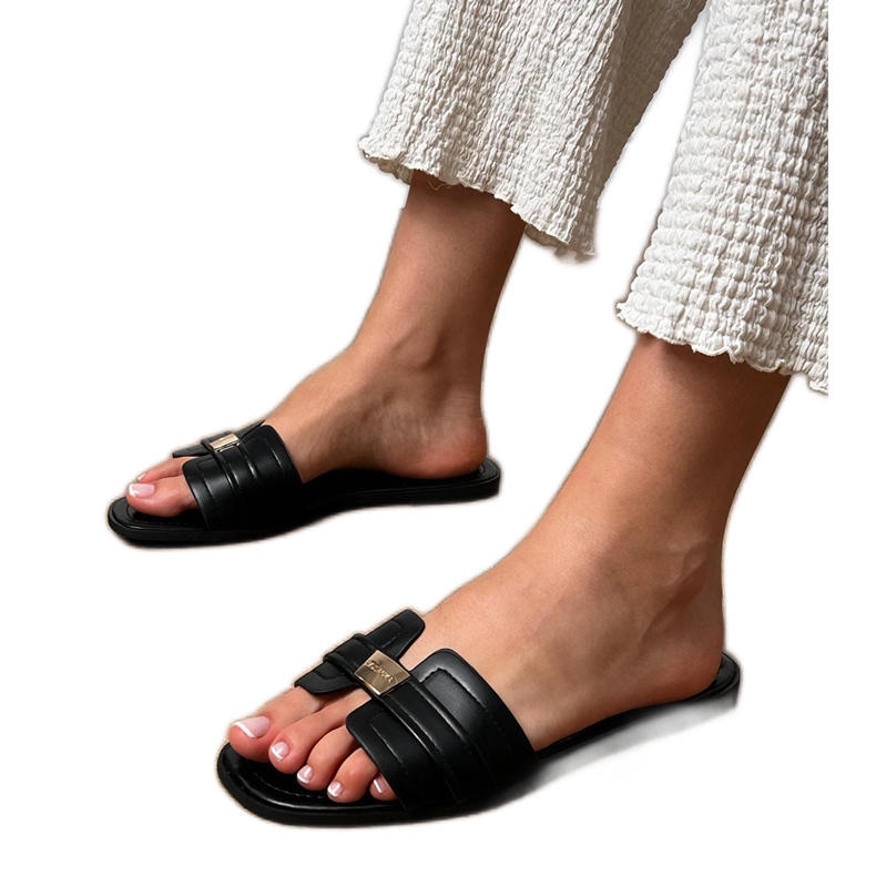 Pantres de femmes noires avec un ornement sur la ceinture le noir Pantres de femmes noires avec un ornement sur la ceinture le noir