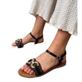 Sandales plates noires avec une décoration dorée le noir