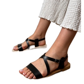 Sandales plates noires avec une ceinture le noir