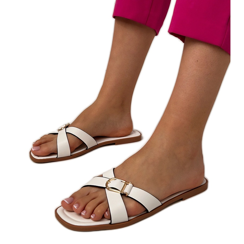 Les tongs blancs avec une boucle décorative sur la ceinture blanche