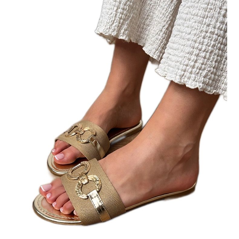 Les tongs dorés avec une décoration dorée sur la ceinture d'or Les tongs dorés avec une décoration dorée sur la ceinture d'or