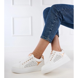 Baskets blanches avec inserts en or sur la plate-forme