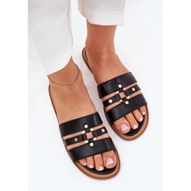 Les tongs plats des femmes avec des détails dorés noirs