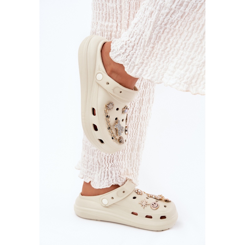 Les tongs en mousse beige avec des épingles