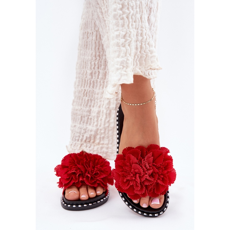 Les tongs des femmes avec des fleurs matérielles rouges