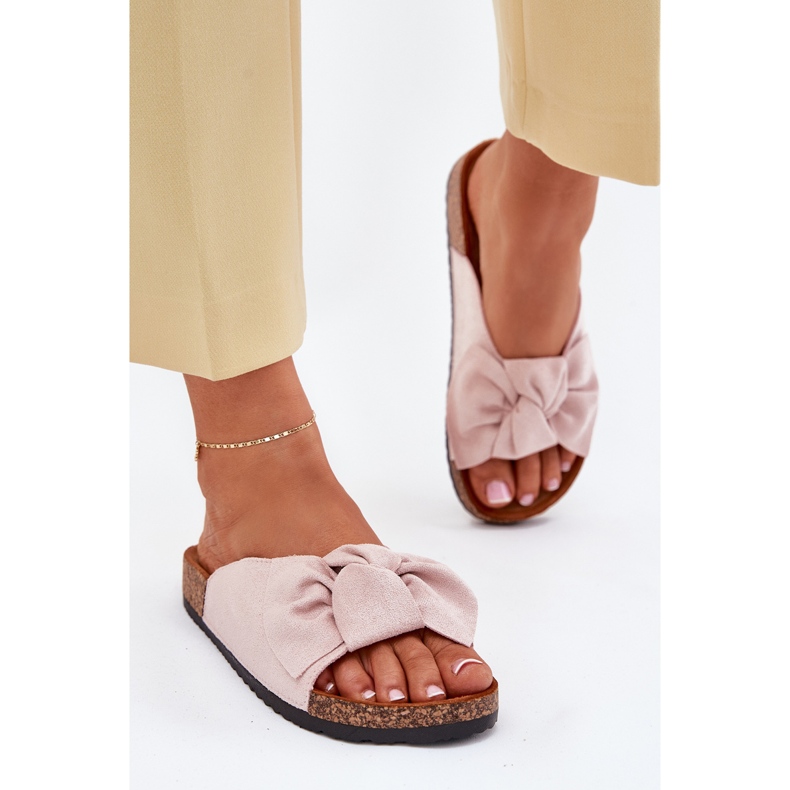 Les tongs des femmes sur la semelle de liège avec un arc rose clair