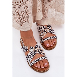 Sandales féminines à talons plats avec des goujons blancs dorés