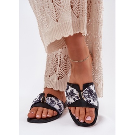 Les tongs des femmes à thèmes plates avec un arc noir