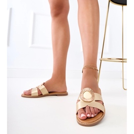 Les tongs dorés avec un ornement doré et des découpes sur la ceinture