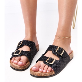 Les tongs des paillettes noires sur la semelle en liège de la flotte