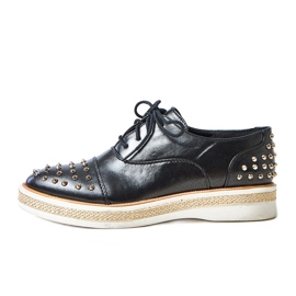 Chaussures des femmes noires avec des goujons de grès le noir