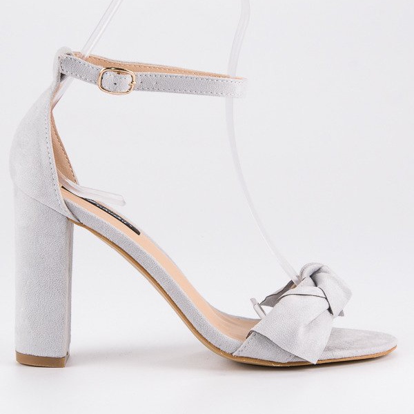 Sandales en daim sur un poteau gris