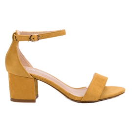 Ch. Creation Sandales classiques sur un bar jaune Ch. Creation Sandales classiques sur un bar jaune