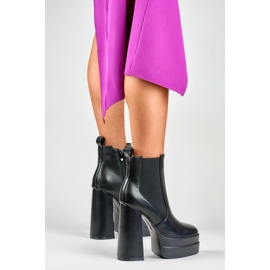 Bottes noires sur un poste élevé et une plate-forme le noir 3