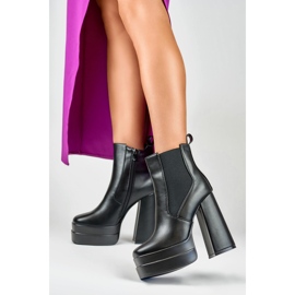 Bottes noires sur un poste élevé et une plate-forme le noir 6