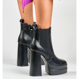 Bottes noires sur un poste élevé et une plate-forme le noir 8