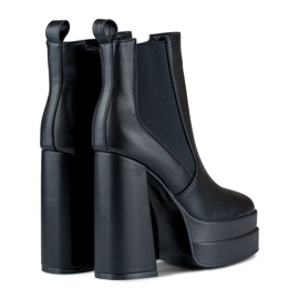 Bottes noires sur un poste élevé et une plate-forme le noir 5