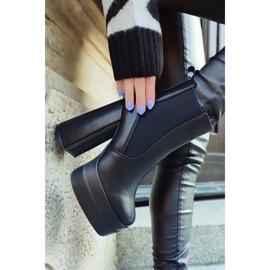 Bottes noires sur un poste élevé et une plate-forme le noir 1