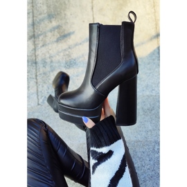 Bottes noires sur un poste élevé et une plate-forme le noir 2