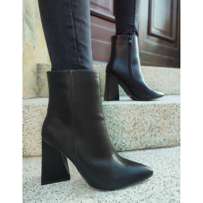 Bottes noires sur un poteau en forme de triangle le noir 1