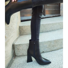 Bottes noires sur un poteau en forme de triangle le noir 2