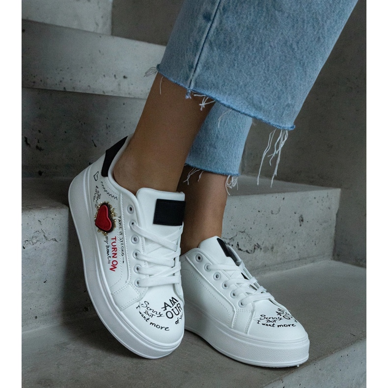 Baskets blanches ornées d'un patch et d'inscriptions sur la plateforme 1