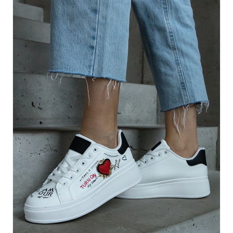 Baskets blanches ornées d'un patch et d'inscriptions sur la plateforme 2