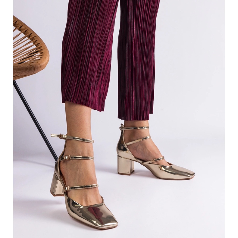 Les pompes dorées ont été vernies sur un poteau avec des boucles 1