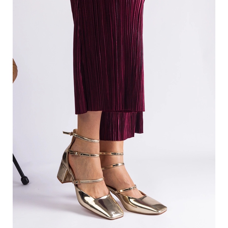 Les pompes dorées ont été vernies sur un poteau avec des boucles 2