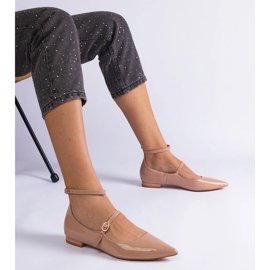 Les pompes beige verni avec des talons plats avec des boucles beiges 1