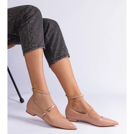Les pompes beige verni avec des talons plats avec des boucles beiges 2