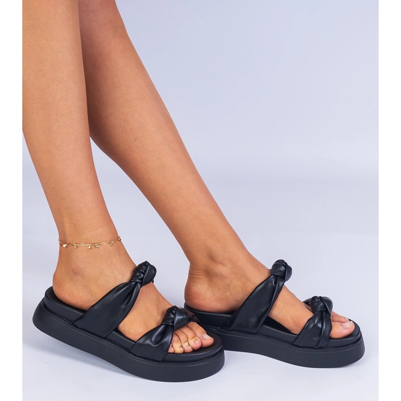 Des pantoufles noires sur la plate-forme le noir 1