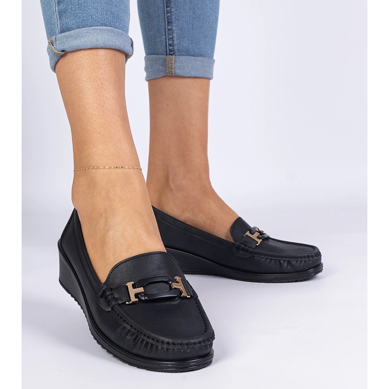 Moccasins des femmes noires sur un coin ancien le noir 1