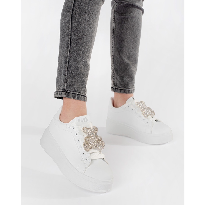 Baskets blanches sur une plate-forme d'ours en peluche 2