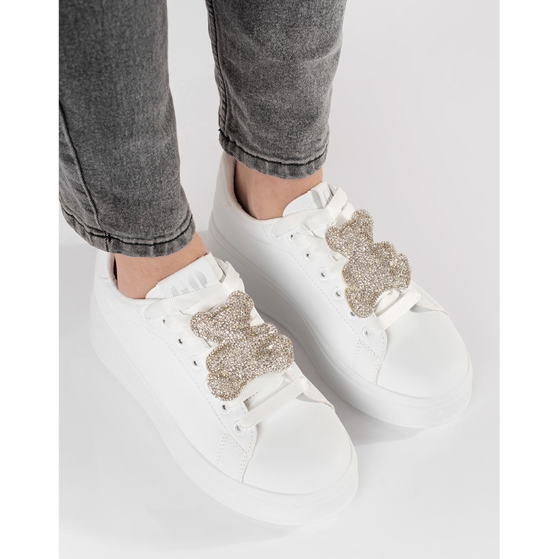 Baskets blanches sur une plate-forme d'ours en peluche 1