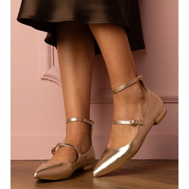 Pompes dorées avec des talons plats avec des boucles 1