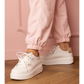 Baskets sportives blanches et or sur la plate-forme 1