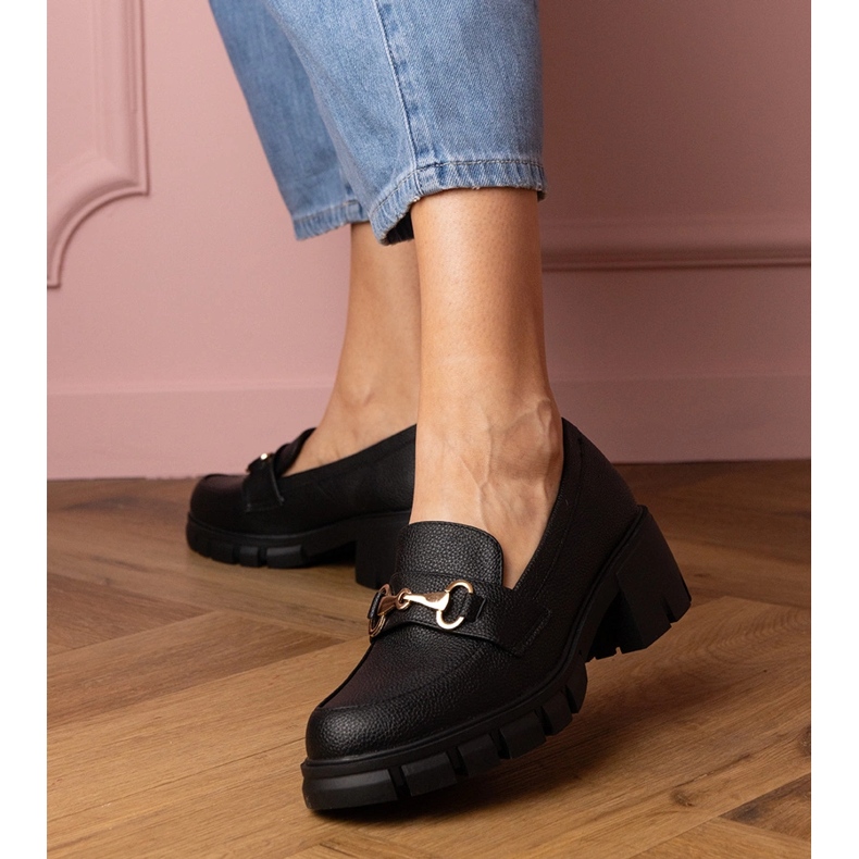 Chaussures noires sur un poteau bas avec une décoration dorée 1