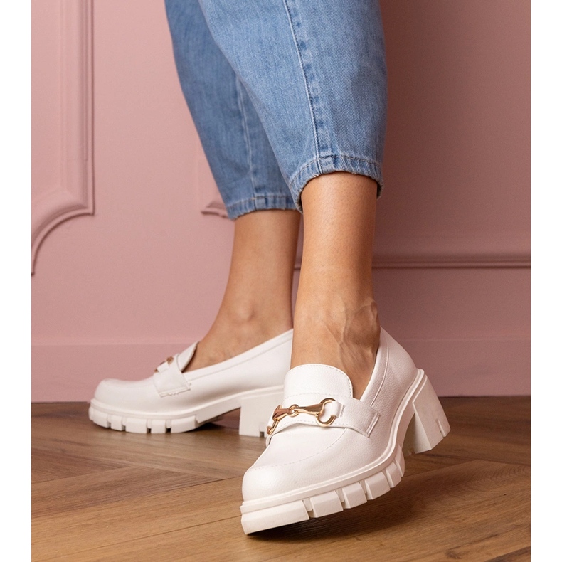 Chaussures blanches sur un poteau bas avec un ornement doré 1