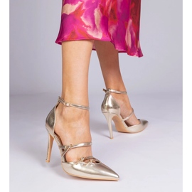 Des pompes dorées sur un talon haut fixé autour de la cheville d'or 1