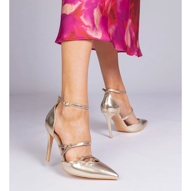 Des pompes dorées sur un talon haut fixé autour de la cheville d'or 1