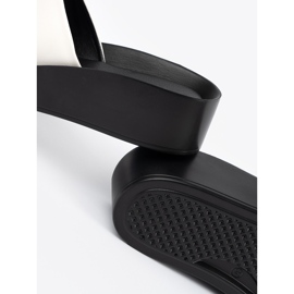 Goodin Les tongs noirs et blancs sur un coin bas blanche 1 Goodin Les tongs noirs et blancs sur un coin bas blanche 1