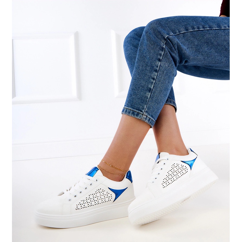 Baskets blanches avec des inserts bleus sur la plate-forme 1