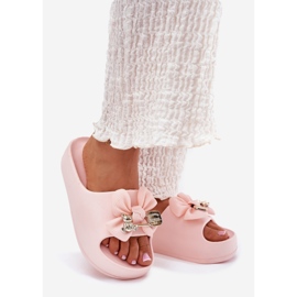 Des pantoufles de mousse pour femmes sur la plate-forme avec un arc et une broche rose 1