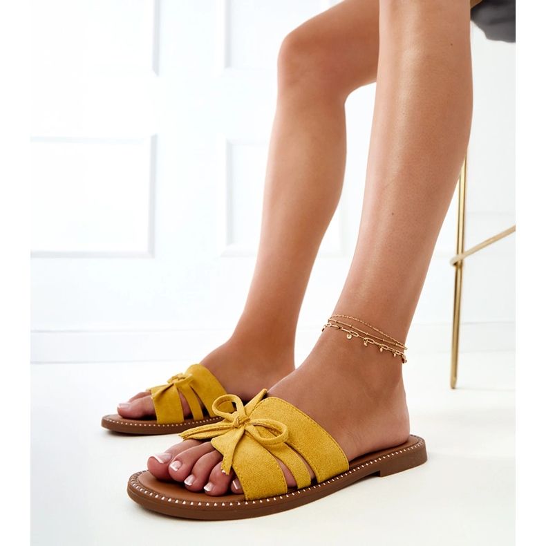 Les tongs jaunes avec un arc et une décoration sur les bords 1