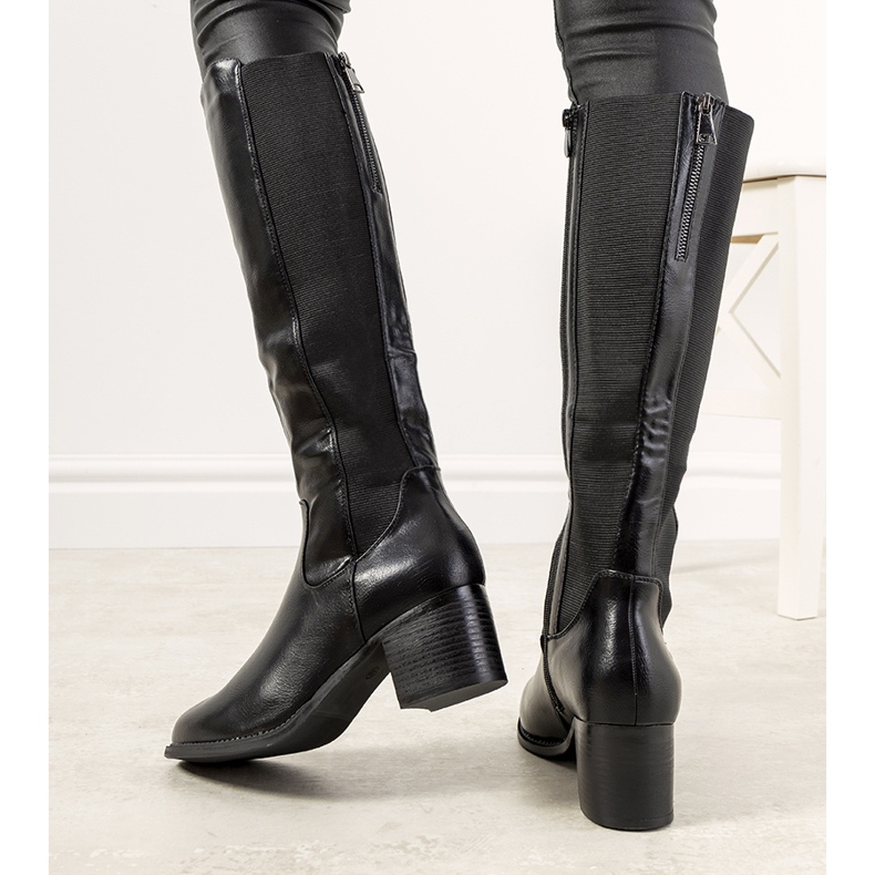 Bottes noires sur le poteau Jurado isolé le noir 1