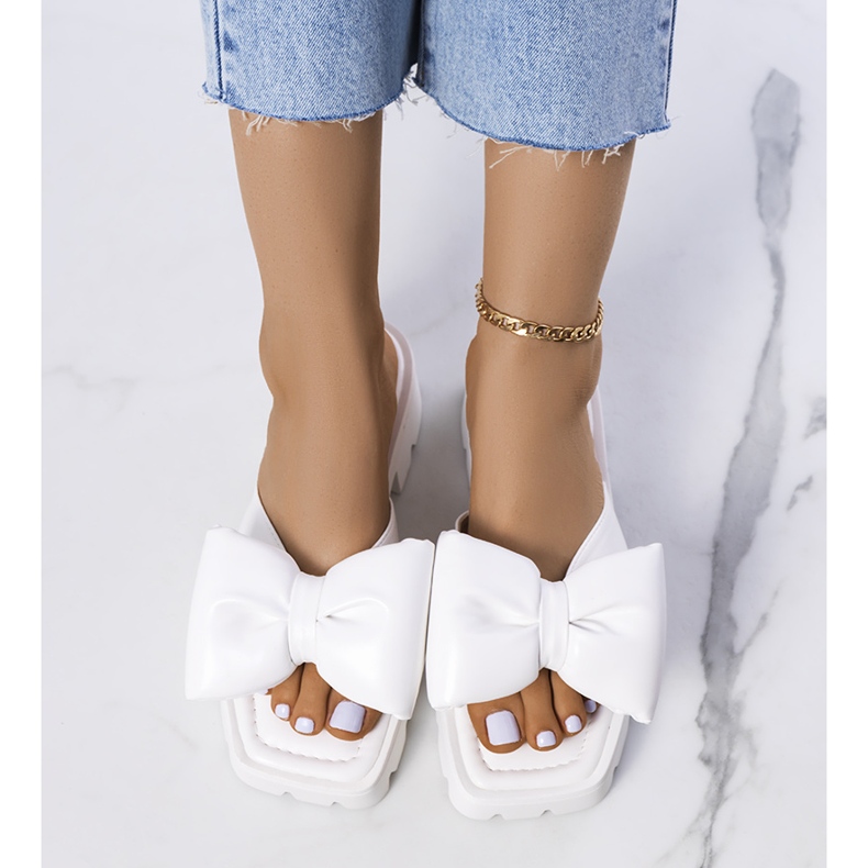 Des pantoufles blanches sur la semelle du tracteur du Platt 1